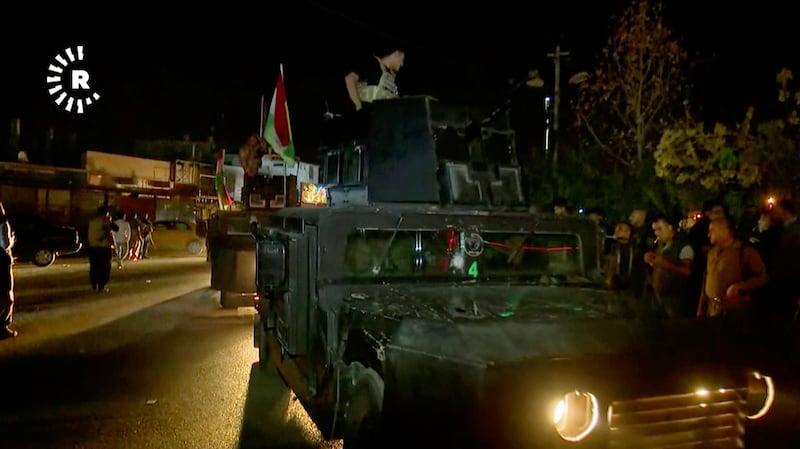 This image made from a video provided by RUDAW TV shows what the Irbil-based Kurdish broadcaster says are Peshmerga fighters and volunteers arriving on military trucks in Kirkuk, Iraq, Monday, Oct. 16, 2017. (RUDAW TV via AP)