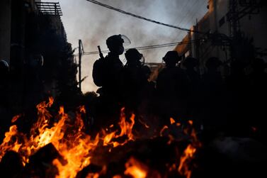 Israeli police officers stand guard next to burning rubbish during clashes with ultra-Orthodox Jews in Bnei Brak on January 24, 2021. AP Photo