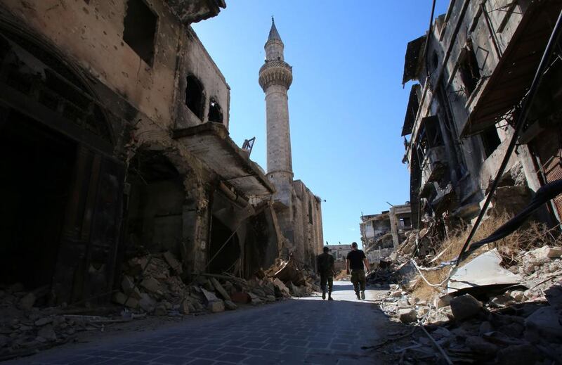 Syrian government soldiers walk in the damaged al-Farafira souk in the government-held side of Aleppo's historic city centre on September 16, 2016. After five years of war, Aleppo's historic city centre, a UNESCO-listed World Heritage site home to an imposing citadel, is a makeshift military barracks. Youssef Karwashan / AFP 

