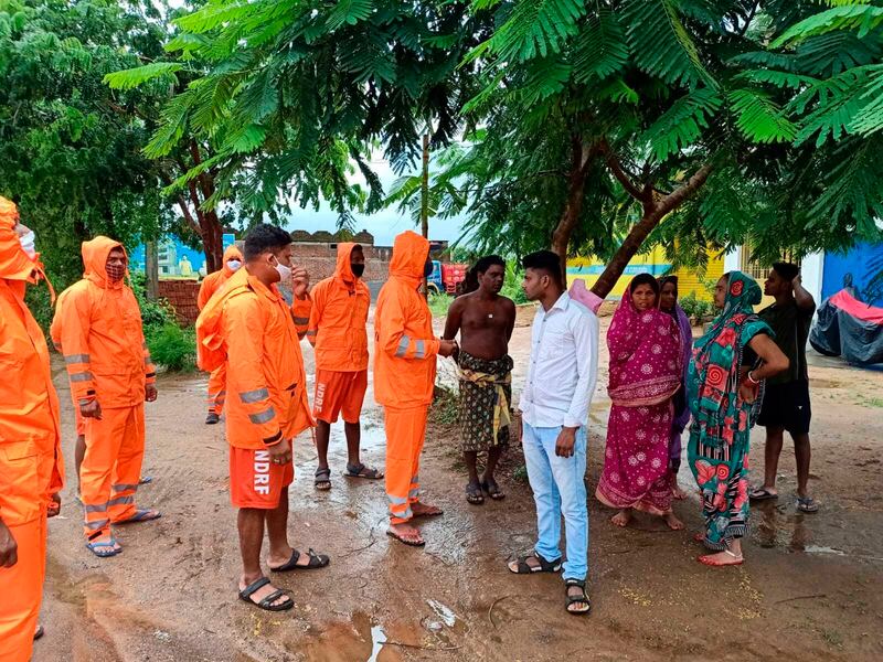 India's National Disaster Response Force personnel ask villagers to take precautions against Cyclone Gulab, that made landfall on Sunday evening at Ganjam. Photo: AP
