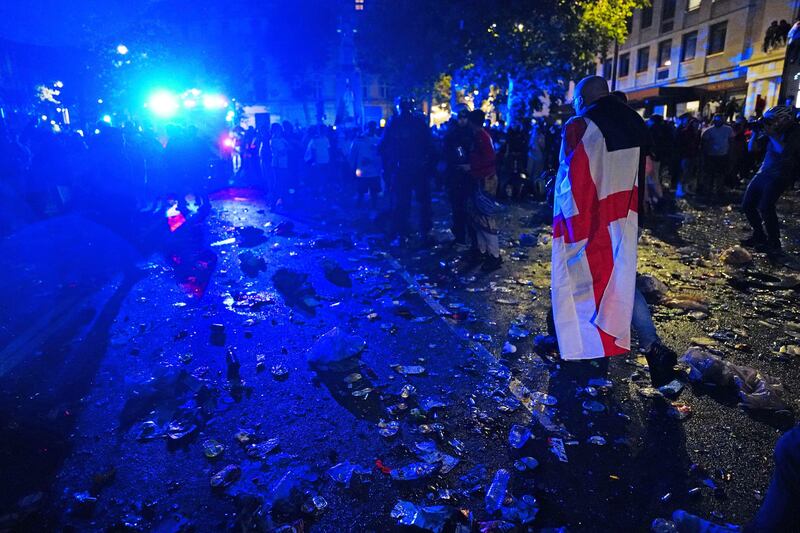 An English fanwalks through litter and broken glass in Trafalgar Square, London.