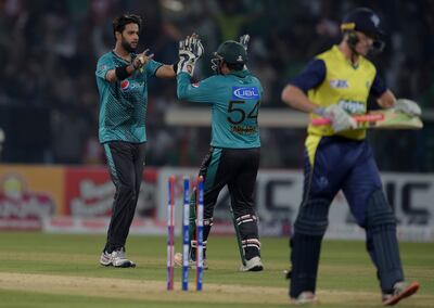 Pakistani spinner Imad Wasim (L) celebrates with captain and wicketkeeper Sarfraz Ahmad (C) after taking the wicket of World XI batsman George Bailey (R) during the third and final Twenty20 International match between the World XI and Pakistan at the Gaddafi Cricket Stadium in Lahore on September 15, 2017.
 / AFP PHOTO / AAMIR QURESHI