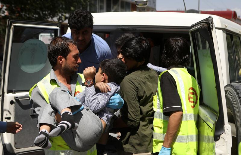 An Afghan health worker carries a wounded school student after a car bomb blast targeted a governmental institution in downtown Kabul.  EPA