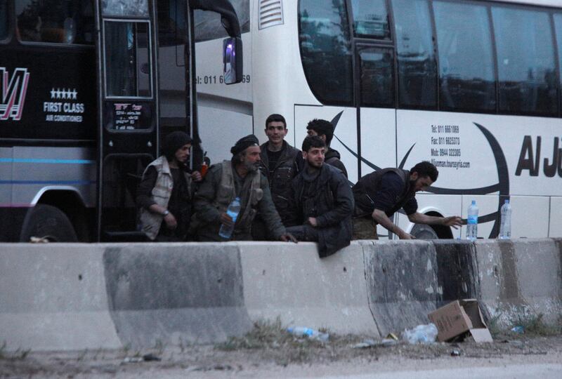 Rebels stand together as they wait to be evacuated, outside Harasta in eastern Ghouta, in Damascus, Syria on March 23, 2018. Omar Sanadiki / Reuters