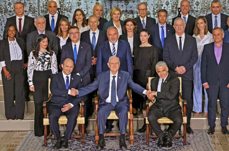 TOPSHOT - Outgoing Israeli President Reuvin Rivlin (C) is flanked by Prime Minister Naftali Bennett (L) and alternate Prime Minister and Foreign Minister Yair Lapid during a photo with the new coalition government, at the President's residence in Jerusalem, on June 14, 2021. A motley alliance of Israeli parties on June 13 ended Benjamin Netanyahu's 12 straight years as prime minister, as parliament voted in a new government led by his former ally, right-wing Jewish nationalist Naftali Bennett. / AFP / EMMANUEL DUNAND

