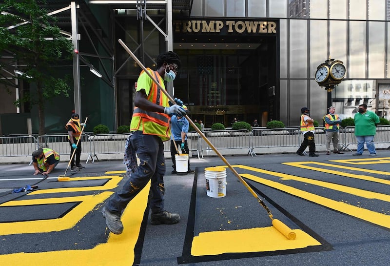 Activists paint a new Black Lives Matter mural outside of Trump Tower on Fifth Avenue in New York City. AFP