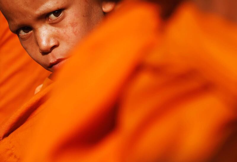 A Buddhist monk sits at the premises of Boudhanath Stupa while waiting for alms during the birth anniversary of Buddha, also known as Vesak Day, at Boudhanath Stupa in Kathmandu, Nepal.  Reuters