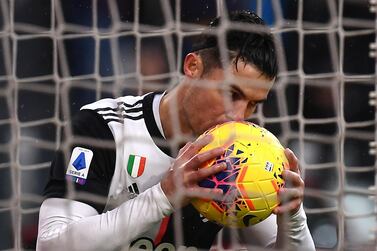 Juventus' Portuguese forward Cristiano Ronaldo kisses the ball as he celebrates after scoring a goal during the Italian Serie A football match Juventus vs Sassuolo on December 1, 2019, at the Juventus Allianz stadium in Turin. / AFP / MARCO BERTORELLO