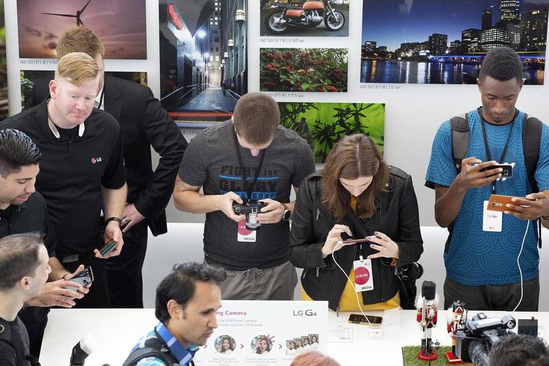 Members of the media look at the LG G4 in New York. Mark Lennihan / AP Photo