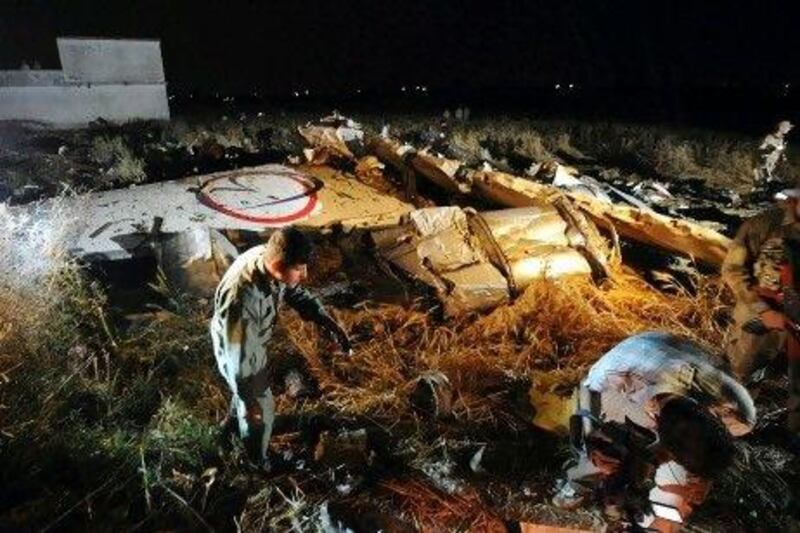 Pakistani rescue workers and residents search through debris at a plane crash site on the outskirts of Islamabad Friday.