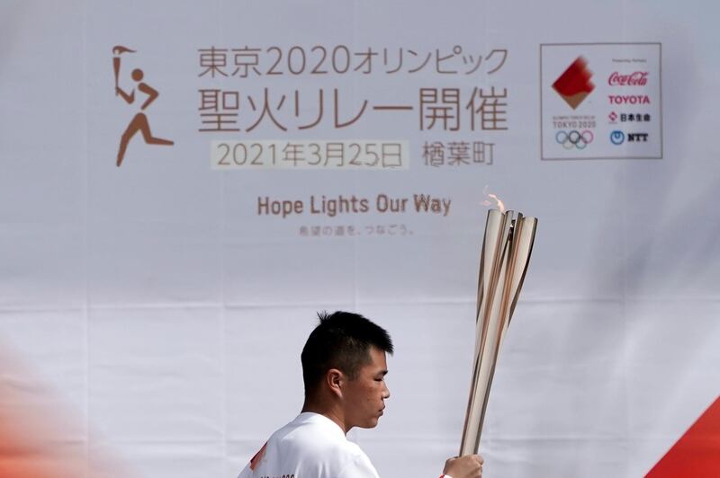 Mahiro Abe, 19, carries the Olympic torch. AP