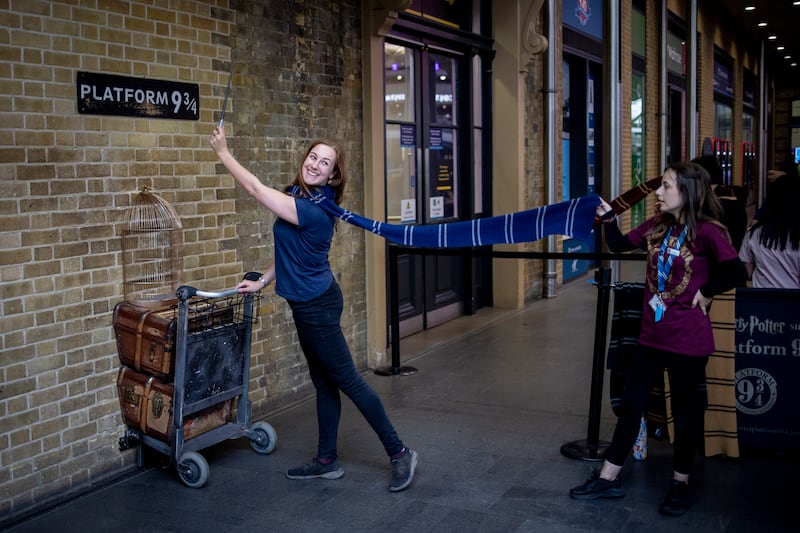 A Harry Potter fan poses at Platform Nine and Three Quarters at King's Cross Station in London. EPA