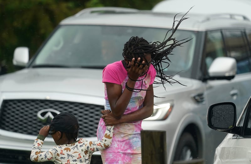 A girl blocks her face from the wind and rain produced by Hurricane Ida in New Orleans. AP