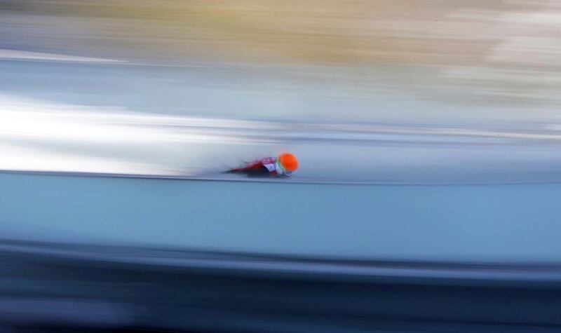 In this slow shutter speed photo an unidentified athlete starts an attempt during the men's normal hill ski jumping training at the 2014 Winter Olympics on Friday. Matthias Schrader / AP