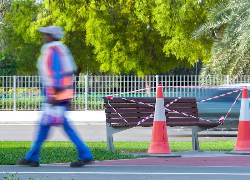 Abu Dhabi, United Arab Emirates, April 9, 2020.  A worker with his packed lunch walks by a cordoned off public bench, to curb the Coronavirus, along the Al Muhadhi pathway, Abu Dhabi.   
Victor Besa / The National
Section:  NA
Reporter: