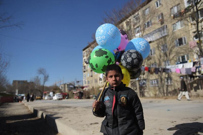 An Afghan child who works as a balloon vendor in Kabul waits for customers. Shah Marai / AFP