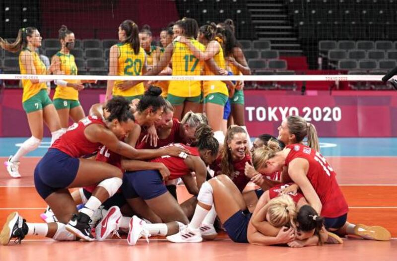US players (celebrate after defeating Brazil in the women's volleyball gold medal match.