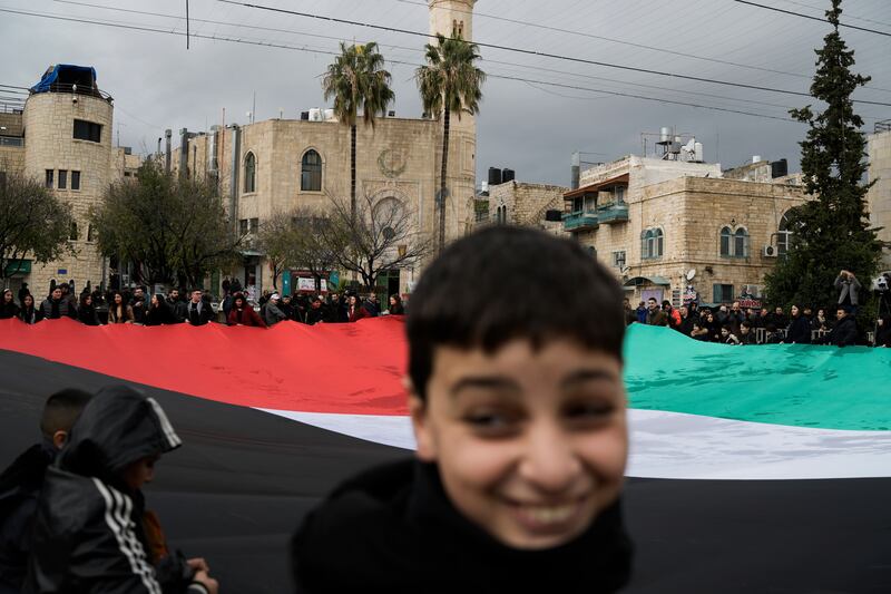 People hold a giant Palestinian flag in Manger Square, near the Church of the Nativity, traditionally believed to be the birthplace of Jesus in the occupied West Bank city of Bethlehem. AP