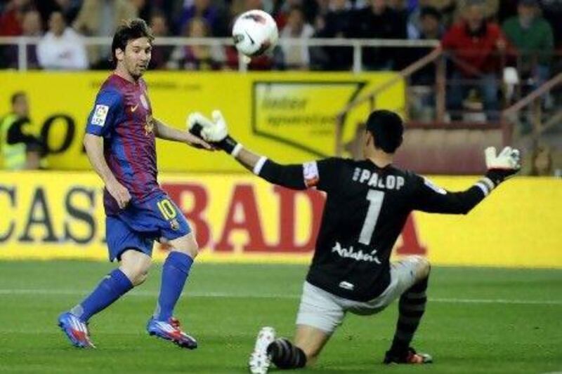 Barcelona's Argentinian forward Lionel Messi (L) scores against Sevilla's goalkeeper Andres Palop (R) during the Spanish League football match Sevilla vs FC Barcelona on March 17, 2012 at Ramon Sanchez Pizjuan stadium in Sevilla. AFP PHOTO / CRISTINA QUICLER
 *** Local Caption *** 110590-01-08.jpg