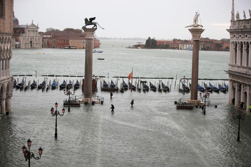 People make their way in a flooded St. Mark's Square in Venice, Italy. AP Photo