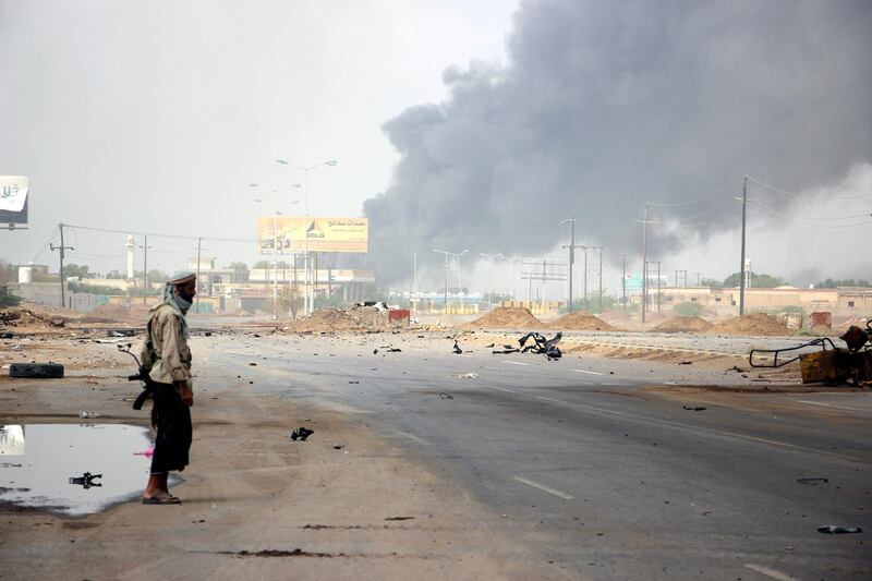 A member of Yemeni government forces stands guard as smoke billows from an alleged Houthi position during battles between Yemeni government forces and Houthi rebels in the port city of Hodeidah, Yemen.  EPA