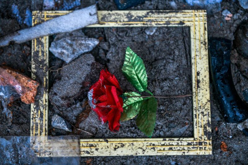 An artificial rose is seen on the floor outside a collapsed home in Rajabasa in Lampung. AFP