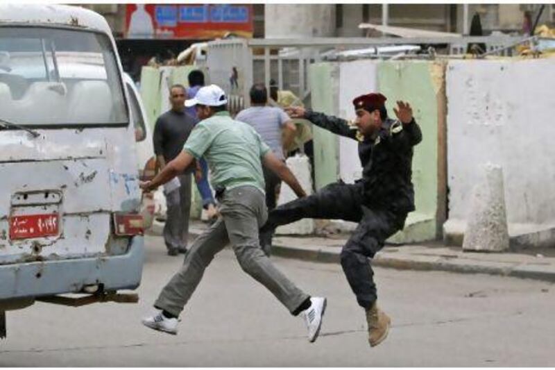 A policeman fights with a man as he tries to arrest him during a protest in Baghdad on  April 22. Iraqis protested in Tahrir Square demanding the withdrawal of the American forces from Iraq and an end to rampant corruption. Police allege that the man was a thief.