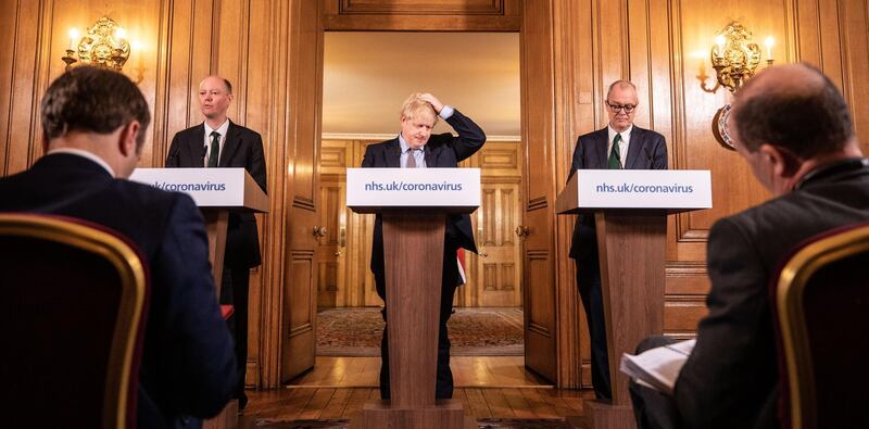 Boris Johnson gestures as Chris Whitty, UK chief medical officer, left, and Patrick Vallance, UK lead science adviser, right, stand during a coronavirus news conference inside number 10 Downing Street on Monday, March 16, 2020. Bloomberg