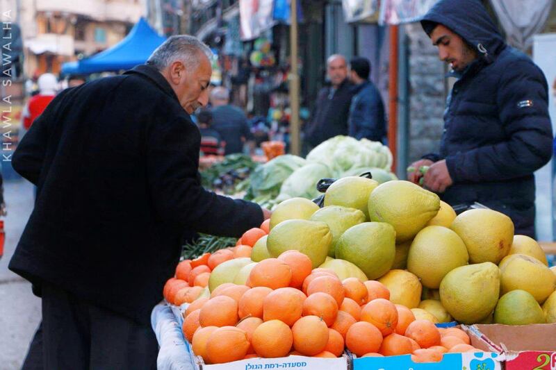 Khawla, Palestine: Khawla takes a well-timed photo of an old man shopping for groceries in the local vegetable market in Hebron, Palestine.  