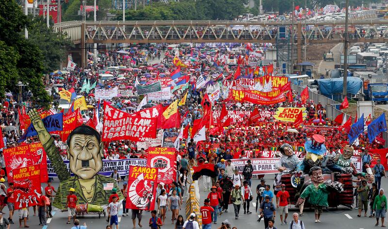 Thousands of protesters march towards the Lower House with an effigy of president Rodrigo Duterte, lower right, to demand that he deliver on a wide range of promises he made in his first state of the nation address last year. Bullit Marquez / AP Photo