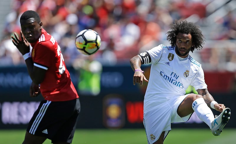 Real Madrid's Marcelo, right, kicks the ball away from Manchester United's Timothy Fosu-Mensah. Ben Margot / AP Photo