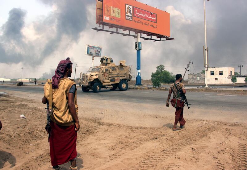 epaselect epa07015224 Yemeni government forces patrol as smoke billows from an alleged Houthi position during battles between Yemeni government forces and Houthi rebels in the port city of Hodeidah, Yemen, 12 September 2018. According to reports, Yemeni government forces, backed by the Saudi-led coalition, seized two major rebel supply routes which link the key port city of Hodeidah with the Houthi-held capital Sana'a, few days after UN-sponsored peace talks in Geneva failed to get off the ground.  EPA/NAJEEB ALMAHBOOBI