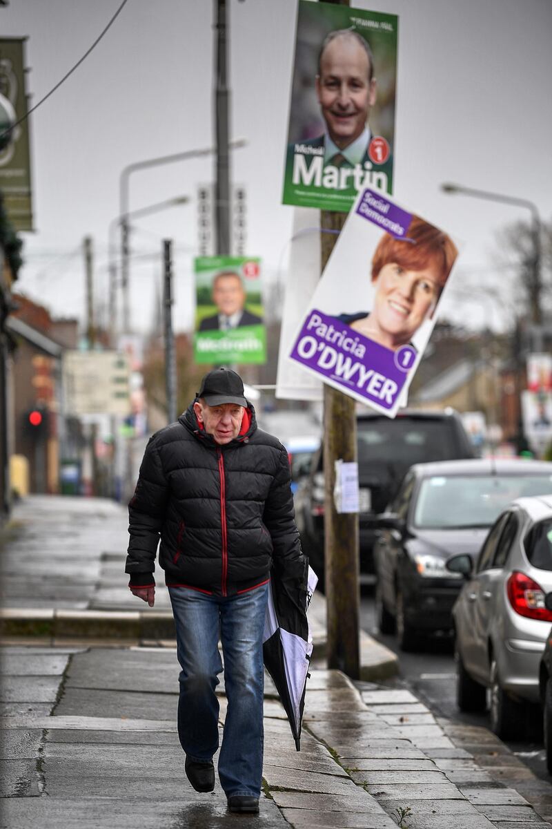 A man walks past election placards near Nagle Hall as Irelands national election takes place in Cork, Ireland. Getty Images