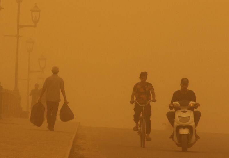 People cross a bridge during a sandstorm in Baghdad. Reuters