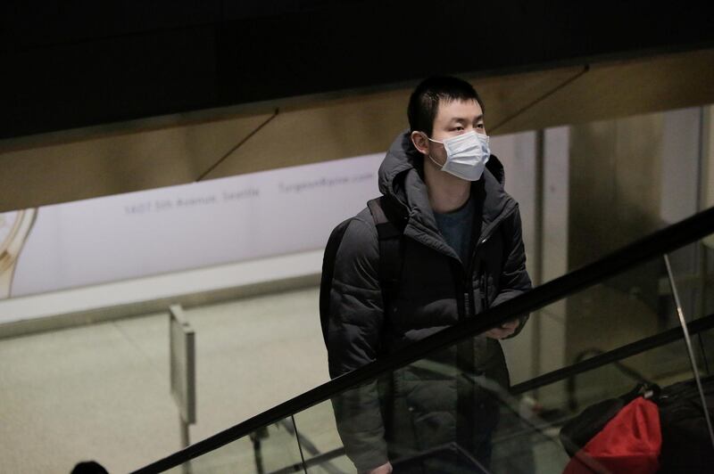 A traveller wearing a mask arrives on a direct flight from China, after a spokesman from the U.S. Centers for Disease Control and Prevention (CDC) said a traveller from China had been the first person in the United States to be diagnosed with the Wuhan coronavirus, at Seattle-Tacoma International Airport in SeaTac, Washington, U.S. January 23, 2020.  REUTERS/David Ryder
