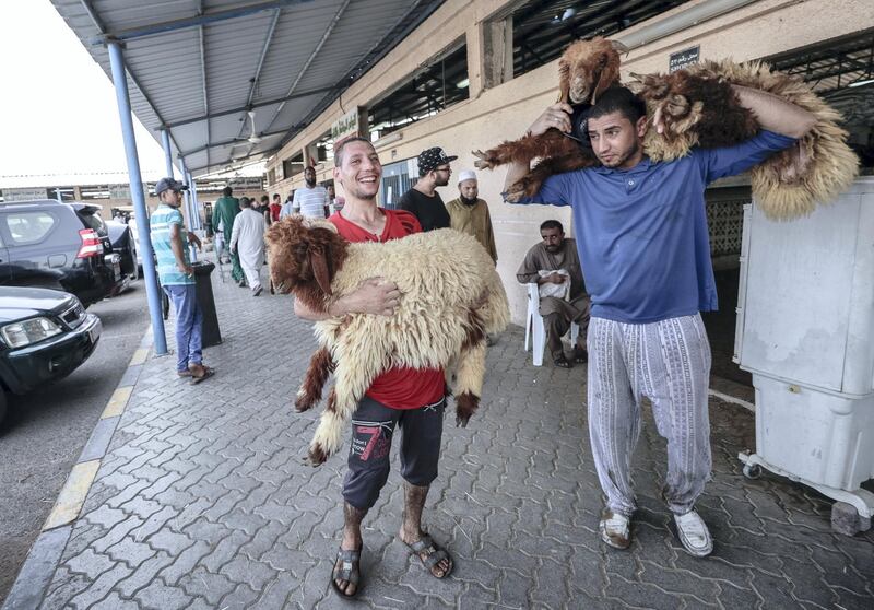 Abu Dhabi, United Arab Emirates, August 11, 2019.   Eid Al Adha at the Mina Livestock Market and Abattoir.-- Livestock market workers carry the goats across the street to the slaughterhouse for proper butchering.
Victor Besa/The National
Section:  NA
Reporter: John Dennehy