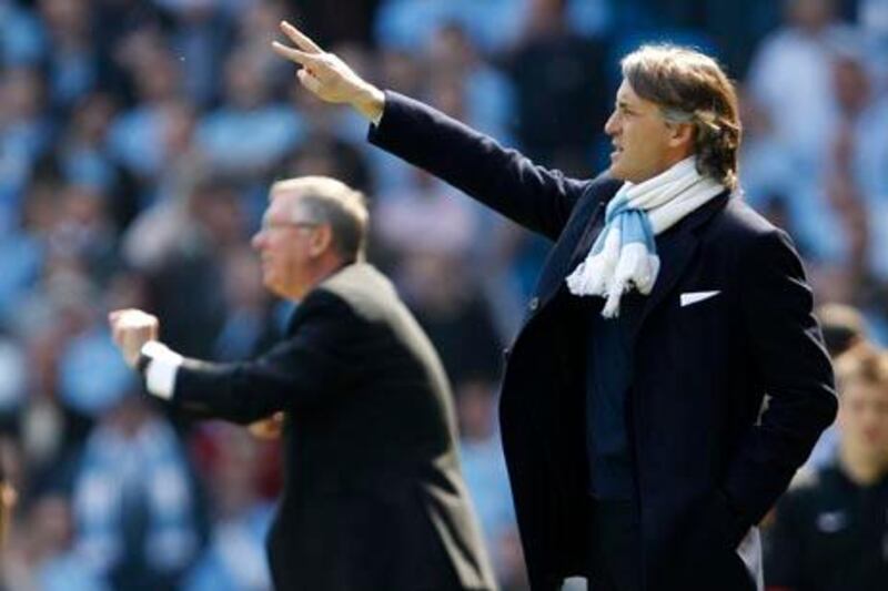 Manchester City's manager Roberto Mancini (R) and his Manchester United counterpart Alex Ferguson (L) gesture during their English Premier League soccer match in Manchester, northern England, April 17, 2010.     REUTERS/Darren Staples (BRITAIN - Tags: SPORT SOCCER) NO ONLINE/INTERNET USAGE WITHOUT A LICENCE FROM THE FOOTBALL DATA CO LTD. FOR LICENCE ENQUIRIES PLEASE TELEPHONE ++44 (0) 207 864 9000