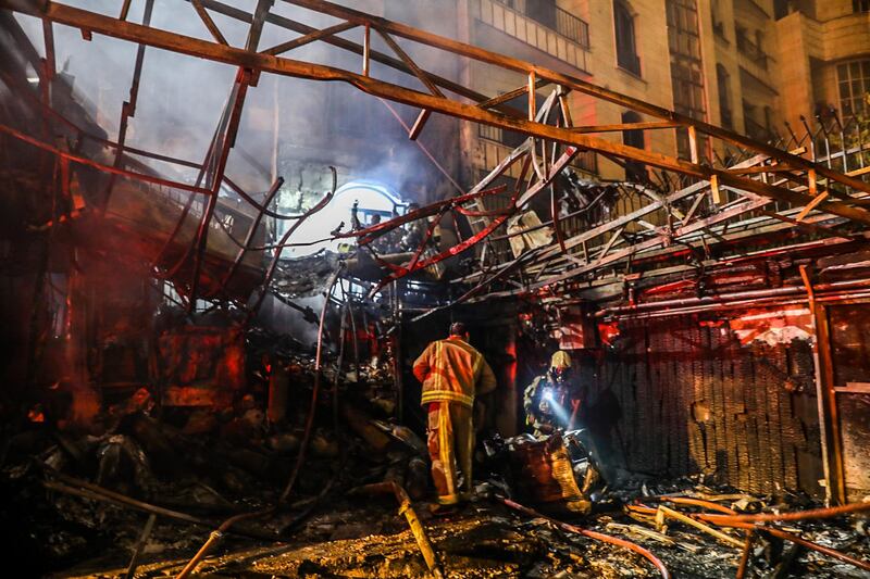 Iranian civil defence inspect the mangled remains of the building. AFP