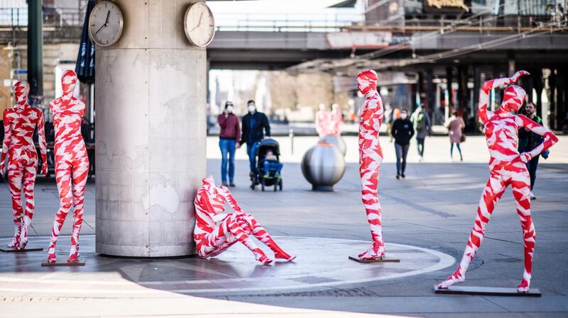 Mannequins wrapped in warning tape, part of the Covid-19 memorial art installation 'It is Like it is,' stand next to the world time clock on Alexanderplatz in Berlin, Germany. EPA