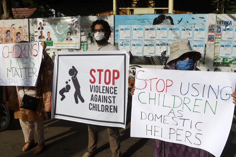 Activists of Civil Society carry placards during a protest against child labour and violence against children, in Karachi on June 8, 2020.  A Pakistan couple have been arrested for allegedly murdering their seven-year-old maid after she was blamed for letting a pet bird escape, police said, the latest case of violence against child domestic workers in the country. / AFP / Asif HASSAN
