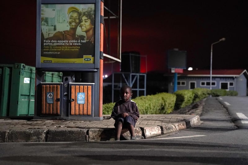 A child sits on the kerb of the Petite Barriere border point between Goma in the DRC and Gisenyi in Rwanda. AFP