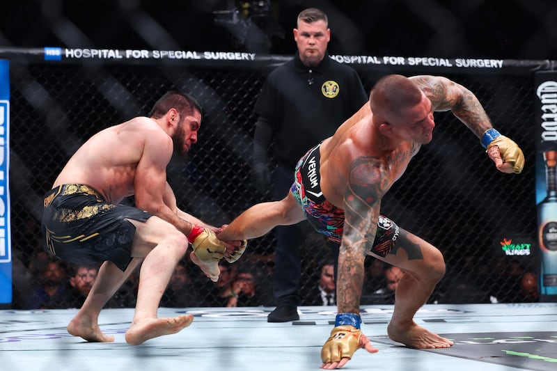 Islam Makhachev grabs hold of Dustin Poirier's leg during their lightweight title bout at UFC 302. AFP