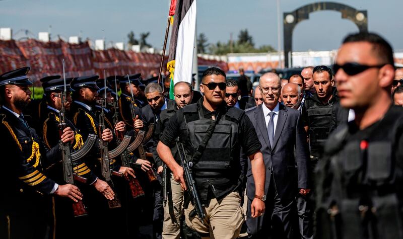 Palestinian Prime Minister Rami Hamdallah (third right), escorted by his bodyguards, is greeted by police forces of Hamas (left) upon his arrival in Gaza City on March 13, 2018. Mahmud Hams / AFP