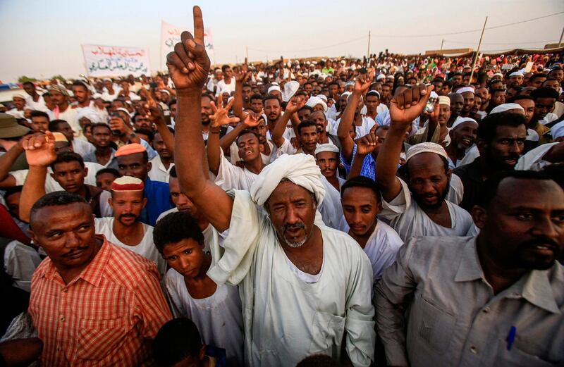 Supporters of the deputy head of Sudan's ruling Transitional Military Council (TMC) and commander of the Rapid Support Forces (RSF) paramilitaries gather and cheer upon his arrival in the village of Qarri, about 90 kilometres north of Khartoum.  AFP