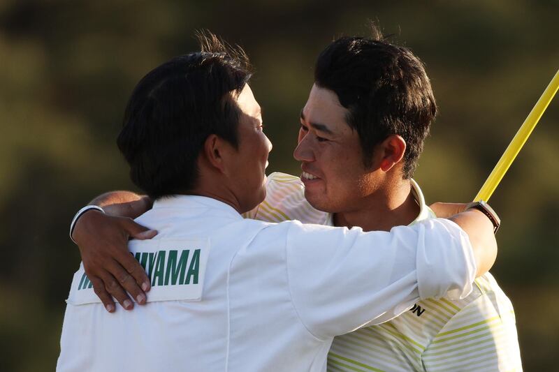 Hideki Matsuyama of Japan hugs his caddie, Shota Hayafuji, on the 18th green. AFP