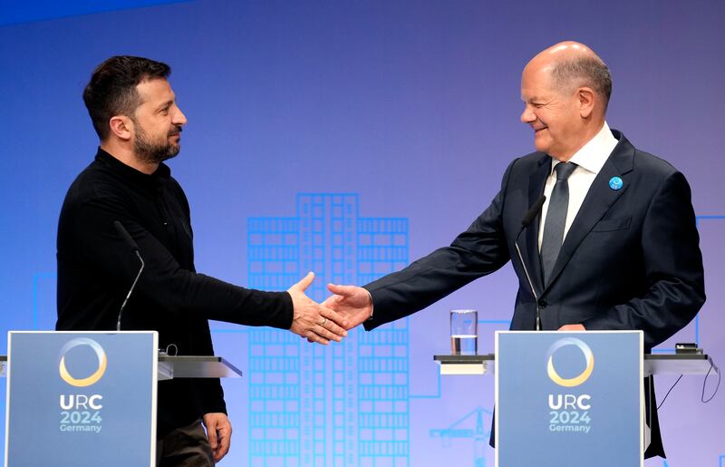Ukrainian President Volodymyr Zelenskyy, left, and German Chancellor Olaf Scholz shake hands after a press conference at the event in Berlin on Tuesday. AP