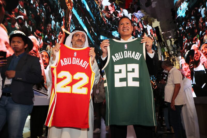 Saleh Mohamed Al Geziry and Ralph Rivera hold up Atlanta Hawks and Milwaukee Bucks jerseys during the NBA Abu Dhabi Games press conference.