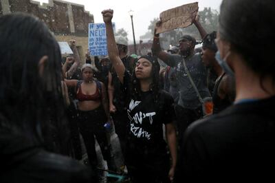 Rain falls as C'Monie Scott raises her fist while people chant around her at a memorial site for George Floyd that has been created at the place where he was taken into police custody and later pronounced dead, in Minneapolis, Minnesota, U.S., June 2, 2020. REUTERS/Leah Millis/File Photo     SEARCH "POY BLM" FOR THIS STORY. SEARCH "WIDER IMAGE" FOR ALL STORIES. TPX IMAGES OF THE DAY REFILE - CORRECTING NAME
