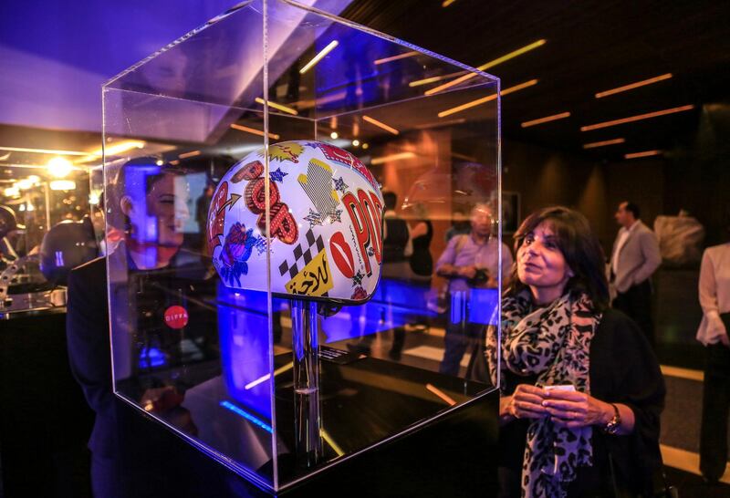 Visitors look at a helmet for a Harley-Davidson motorcycle custom designed by Lebanese artist Rana Salam, during an auction dubbed 'Art Saves Lives' at the Yacht Club Beirut in Lebanon. EPA