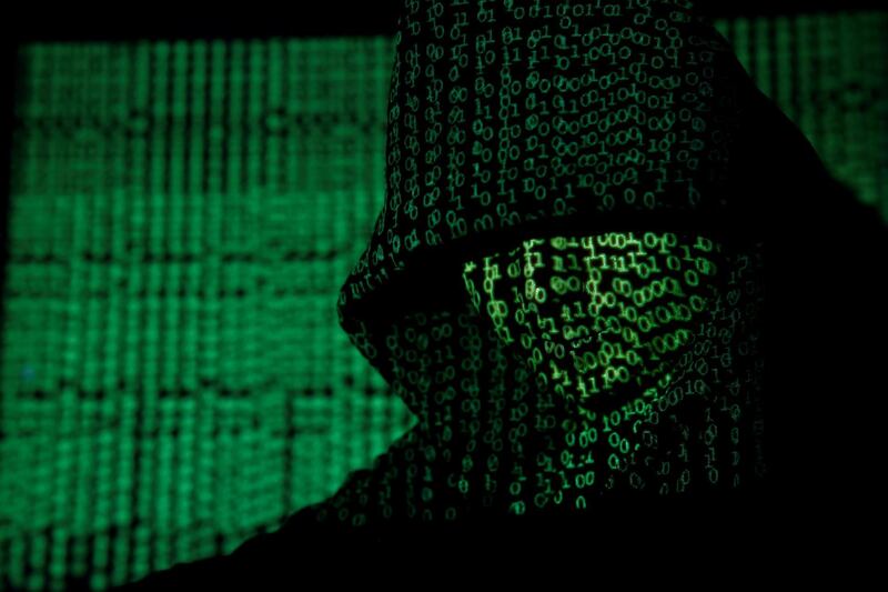 FILE PHOTO: A projection of cyber code on a hooded man is pictured in this illustration picture taken on May 13,  2017. REUTERS/Kacper Pempel/Illustration/File Photo